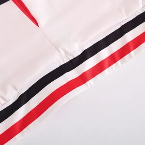 Closeup of children sportswear hem with classic black and red stripes on clean white fabric detail.