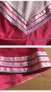 Cheerleading uniform detail close up showing pink fabric with white triple stripe trim and V-neck.