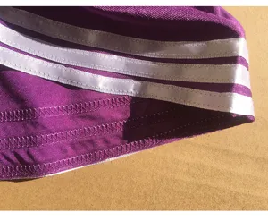 Close-up detail of purple cheerleading uniform hem featuring three parallel white stripes.
