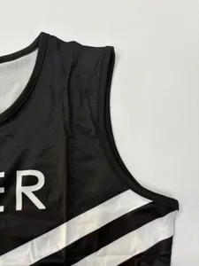 Close-up of adult cheerleading uniform top featuring black sleeveless design with white stripes.