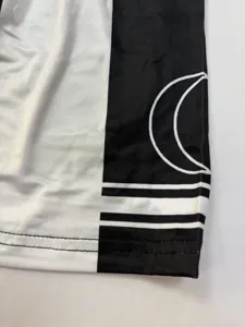 Detail view of the black and white cheerleading dress fabric featuring moon and stripe print.