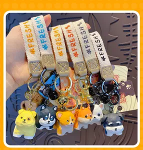 Detailed view of wood-carved style dog family keychains featuring cute puppy pendants and colorful straps.