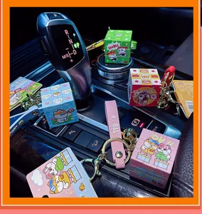 Gros plan de mini porte-clés cube de Rubik mignons avec des motifs d'animaux dans une voiture.