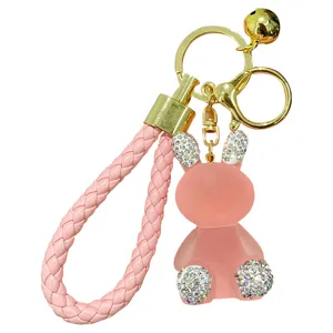 Cute pink rhinestone resin rabbit keychain with braided strap, perfect bag charm.
