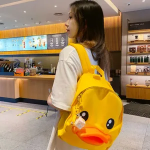 Cute yellow duck backpack for women and students, stylish casual cartoon school bag with pendant.