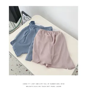 Detailed view of women's loose silk-like loungewear shorts with side split and elastic waist.