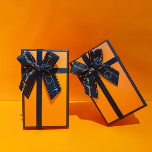 Luxus orangefarbene Geschenkschachtel mit blauem Band für Geburtstag und Partys.