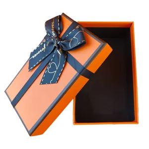 Luxus orange Geschenkschachtel mit elegantem dunklem Schleifenband, ideal für Geburtstage.