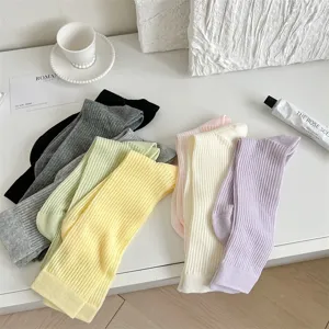 Vue détaillée de chaussettes mi-mollet côtelées colorées pour femmes dans des tons pastel.