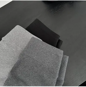 Detail shot of ribbed knit fabric shorts cuffs in black and grey colors, showing soft texture.