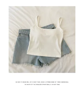 Witte gevoerde camisole met vierkante hals gecombineerd met lichte denim shorts, detail.