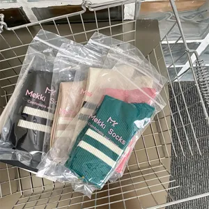 Detail shot of women casual mid-tube socks featuring two-stripes design in individual packaging.