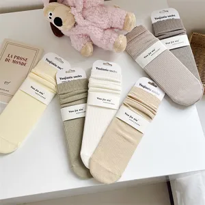 Detail shot of solid color ribbed cotton mid-tube socks, soft texture and neat packaging display.