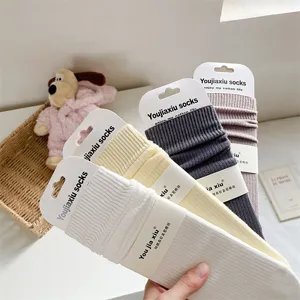 Women's solid color ribbed cotton mid-calf socks with packaging card, soft and cozy.