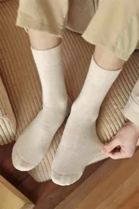 Detailaufnahme von dicken gerippten Baumwollsocken in neutralem Haferton, weiche Textur.