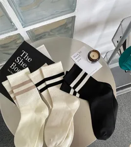 Close-up detail of stylish double striped mid-calf socks displayed on a round table.