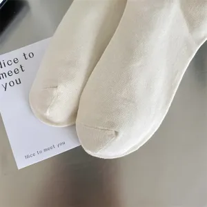 Detailed view of casual women cream white solid color crew socks showing soft knit texture.