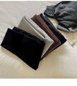 Vue détaillée de pulls en tricot pliés multicolores, texture douce, mode automne confortable.