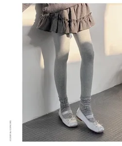 Close-up detail of women's warm thermal fleece-lined tights with grey socks and shoes.