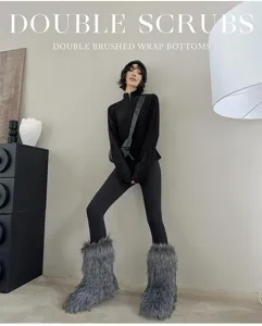 Detailed view of the women's half-zip top and tight leggings outfit in a minimalist indoor scene.