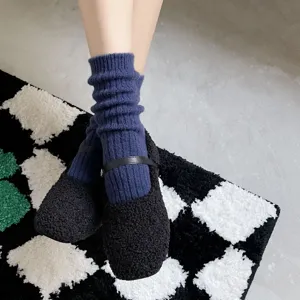 Nahaufnahme Detail mit gemütlichen blauen gerippten Socken kombiniert mit flauschigen Schuhen.