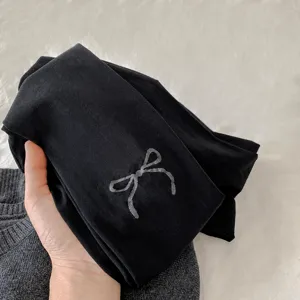 Medias negras de mujer con elegante diseño jacquard de lazo, suaves y estilosas para otoño.
