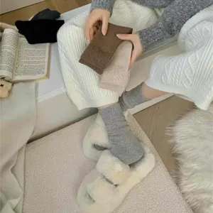 Primer plano de calcetines de lana de invierno gruesos y acogedores sostenidos en el interior.