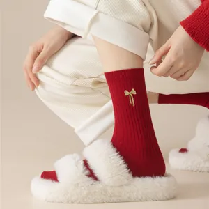 Red cotton women mid-tube socks featuring elegant gold bow embroidery for winter season.