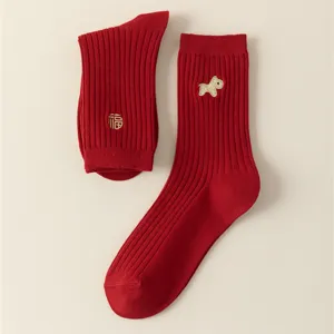 Red cotton socks detail showcasing gold embroidery craftsmanship and festive New Year style.