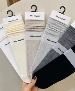 Detailed view of stacked ribbed crew socks in multiple assorted colors with packaging headers.