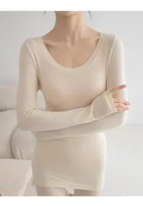 Primer plano del detalle de capa térmica base en color beige para mujer con mangas y pulgares.