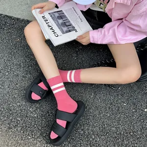 Women fashion pink mid tube socks with white double stripes, comfortable cotton casual wear.