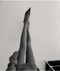 Vista dettagliata di collant grigi senza cuciture da donna con motivo a fiocco.