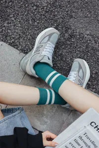 Green striped mid-tube socks detail view showing classic knit texture and daily style