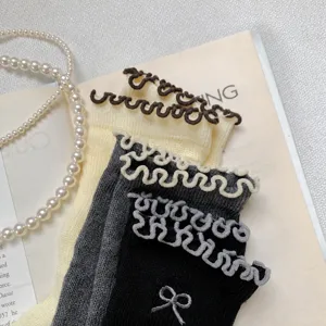 Chaussettes mi-hautes pour femmes avec bords volantés mignons et broderie de nœud délicate.