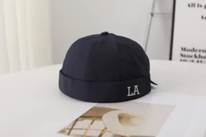 Detail of men's quick-drying brimless docker cap in navy blue with LA letter print for summer.