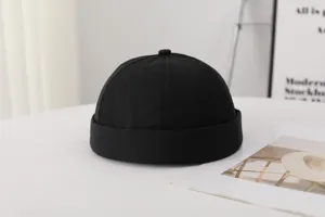 Vista detallada de gorro sin ala negro liso, estilo simple y versátil para el día a día.