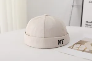 Gros plan de la casquette beige sans visière avec broderie NY noire élégante.