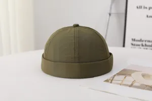 Vista detallada del gorro docker liso verde oliva, tocado casual diario minimalista.