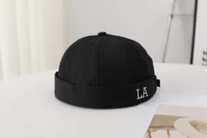Detail view of black brimless docker cap featuring LA letter embroidery, summer hat.
