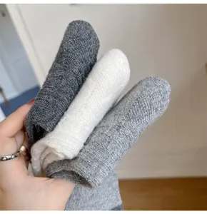 Detailed view of women's wool blend mid-tube socks featuring 3d cable knit texture.