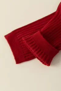 Close-up detail of red ribbed knit socks, showing soft cotton texture and folded cuff.