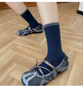 Close-up detail shot of women's dark blue wool-blend mid-calf socks with grey contrast ribbed cuff.