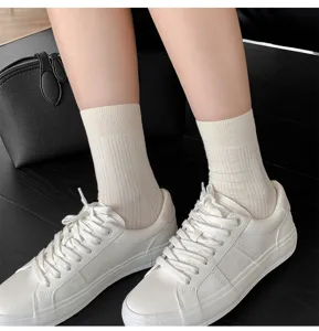 Vue détaillée de chaussettes en coton côtelé pour femmes en beige, associées à des baskets.