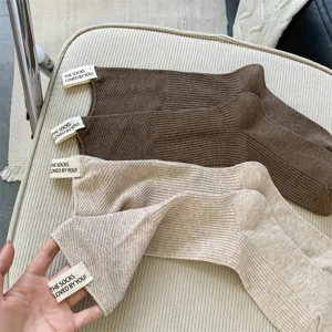Detailansicht gerippter Baumwoll-Wadensocken in Braun und Beige mit dekorativem Textiletikett.