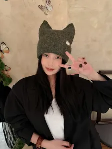 Vista detallada del gorro de punto de orejas de gato verde oscuro, lana suave de invierno.