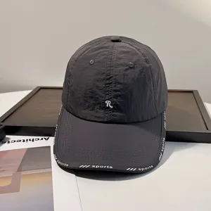 Nahaufnahme Detail der dunkelgrauen schnelltrocknenden Kappe mit R Stickerei und Sportprint.