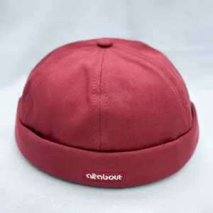 Vista detallada de un gorro docker de algodón rojo, con diseño limpio y una pequeña etiqueta.