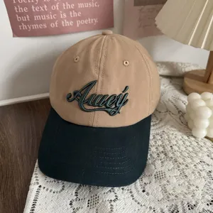 Close-up detail of two-toned casual baseball cap with green embroidery, daily lifestyle aesthetic set.