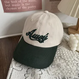 Detailed close-up of two-tone baseball cap with green brim and contrast embroidery design.